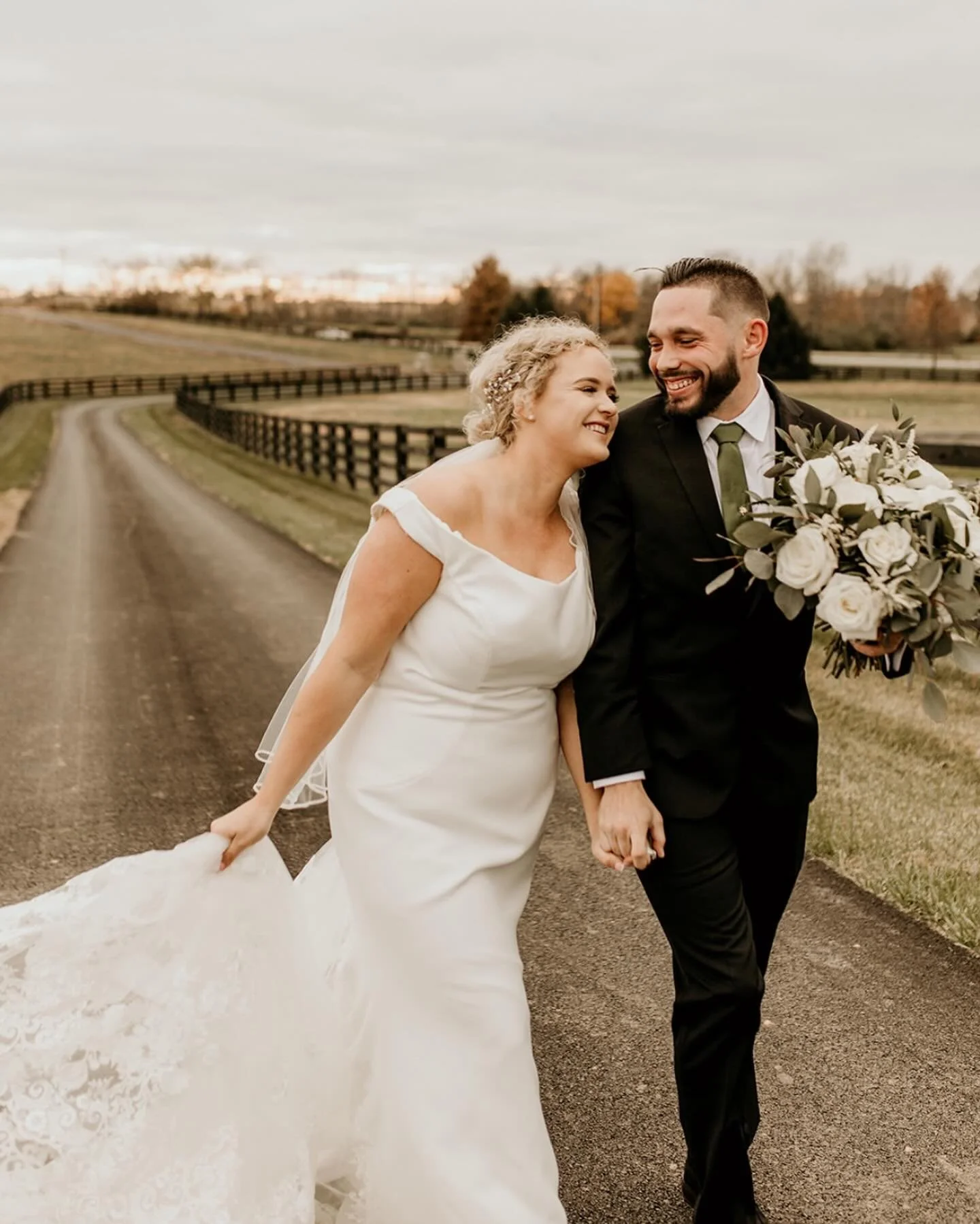 Bride and groom laughing together on the drive at The Show Barn